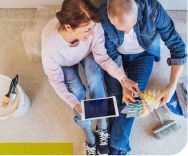 Frau und Mann suchen auf Farbenpalette nach passende Farben für die Wände